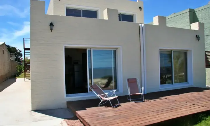 Casa con deck de madera y reposeras