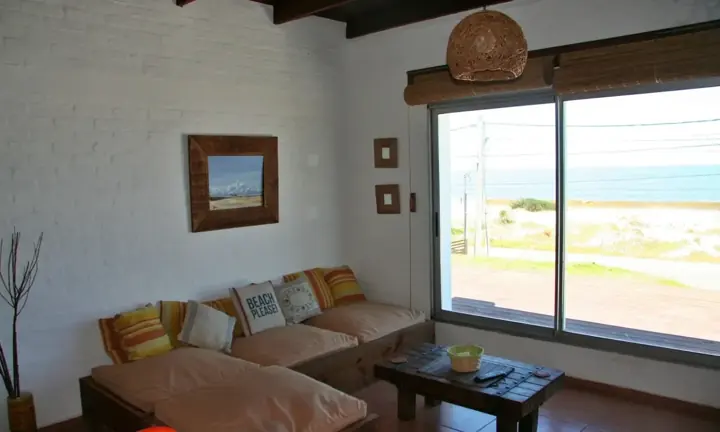 Living con sillón y ventanal que da al mar