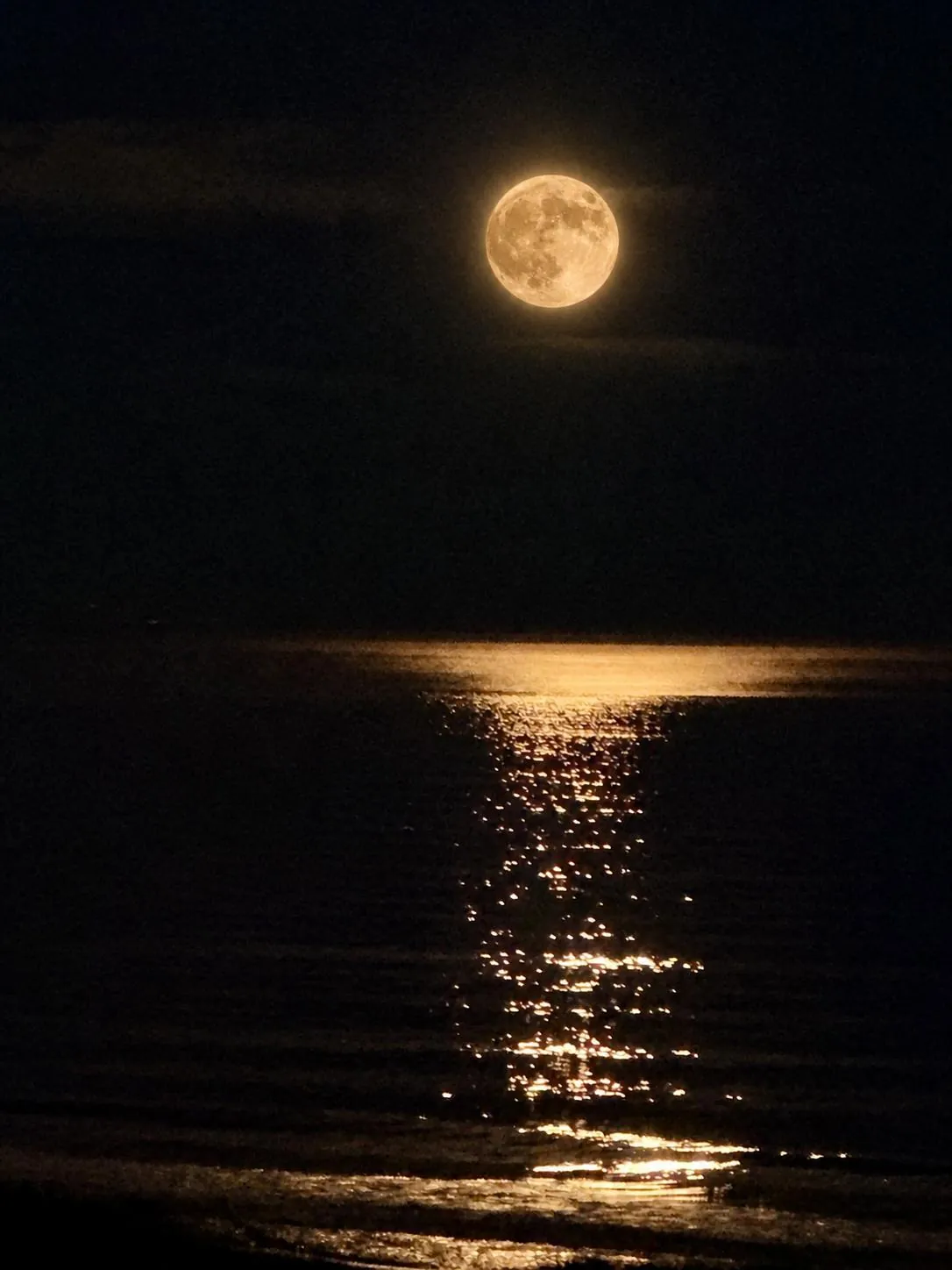 Luna llena reflejada sobre el mar de noche